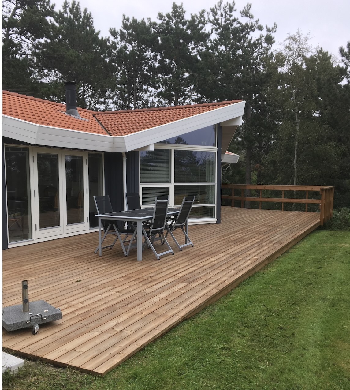 Træterrasse mellem to sorte hytter
